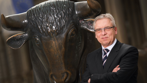 Klaus Nieding steht neben dem Bronce-Bullen der Börse Frankfurt