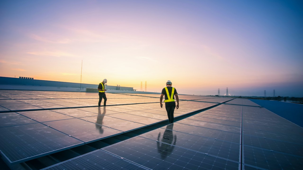 Zwei Arbeiter auf einem Dach mit Solar Anlagen