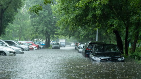 Autos stehen bei Starkregen im Hochwasser