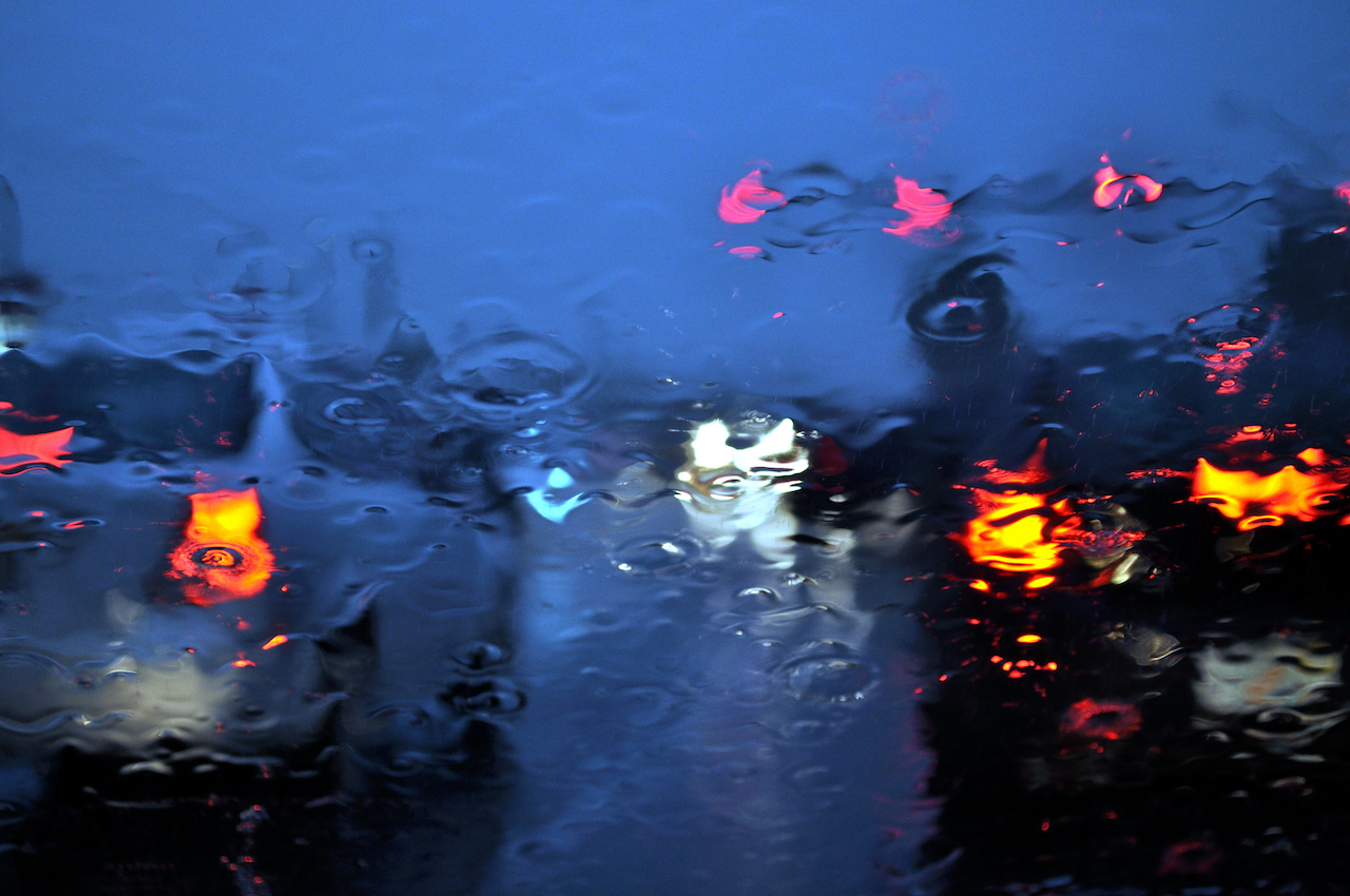 Rainy car windshield with shallow depth of field.