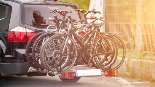 Familienausflug mit Fahrrädern auf Gepäckträger auf Landstraße