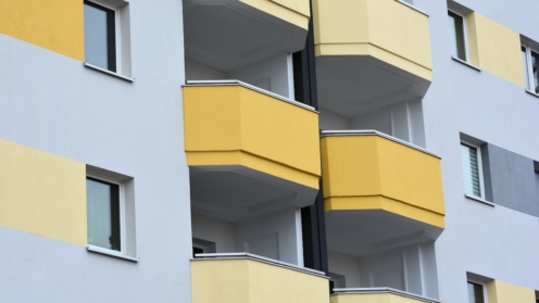 Fassade eines Mehrfamilienhauses mit gelben Balkonen