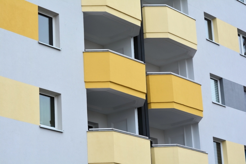 Fassade eines Mehrfamilienhauses mit gelben Balkonen